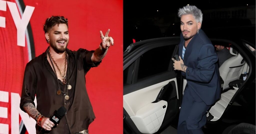 A person in a brown shirt, gold pants, and multiple necklaces smiles and holds up their hand in a V shape in front of a red background.