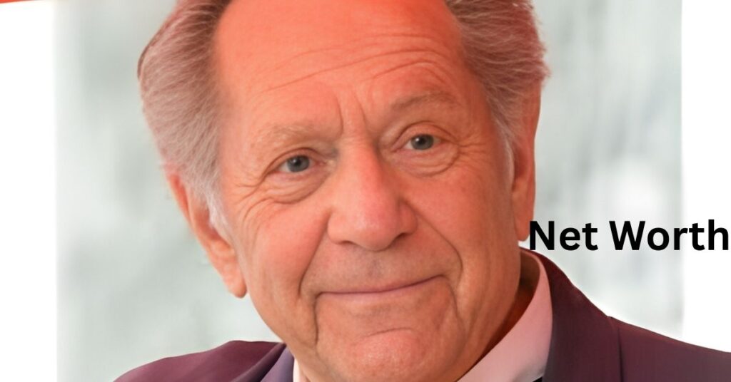 A person poses in a suit jacket.