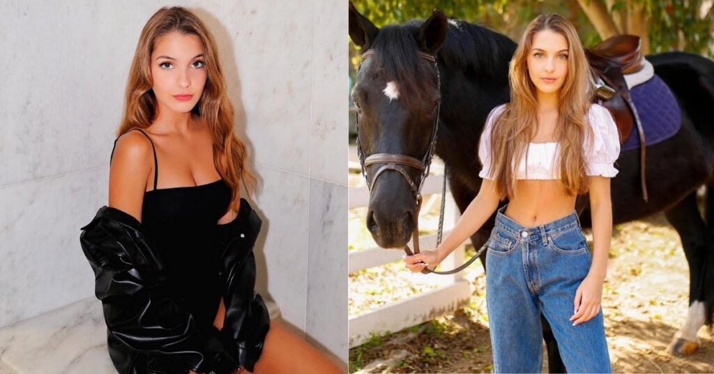 A person stands next to a saddled black horse, holding its reins. The person wears a white crop top and blue jeans.