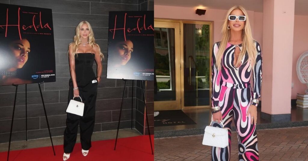 Alexia Echevarria in colorful retro-patterned jumpsuit with white heels and handbag poses outside a pink building entrance.