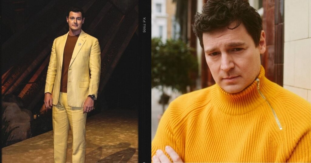Benjamin Walker, with dark, curly hair, wears a bright yellow turtleneck sweater with a silver zipper.