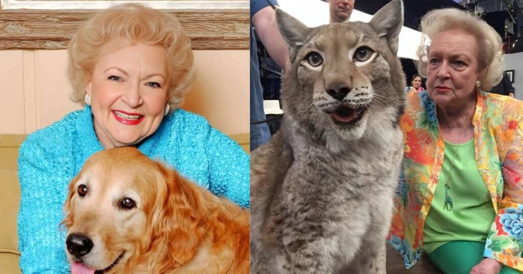 Betty White, in a blue textured jacket, smiles while posing with a golden retriever dog.