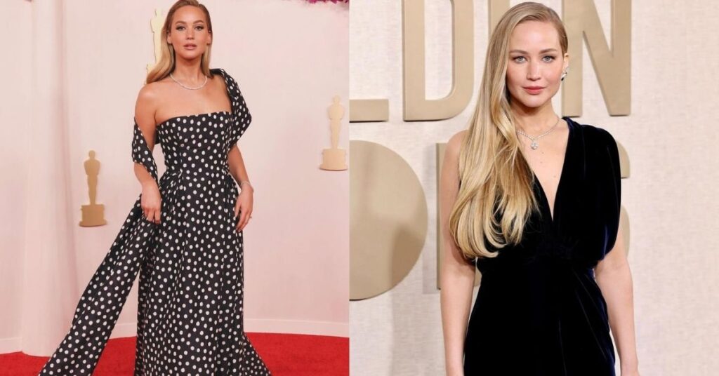 Jennifer Lawrence, wearing a dark blue velvet dress and a diamond necklace, is holding a jeweled clutch. They have long blonde hair.