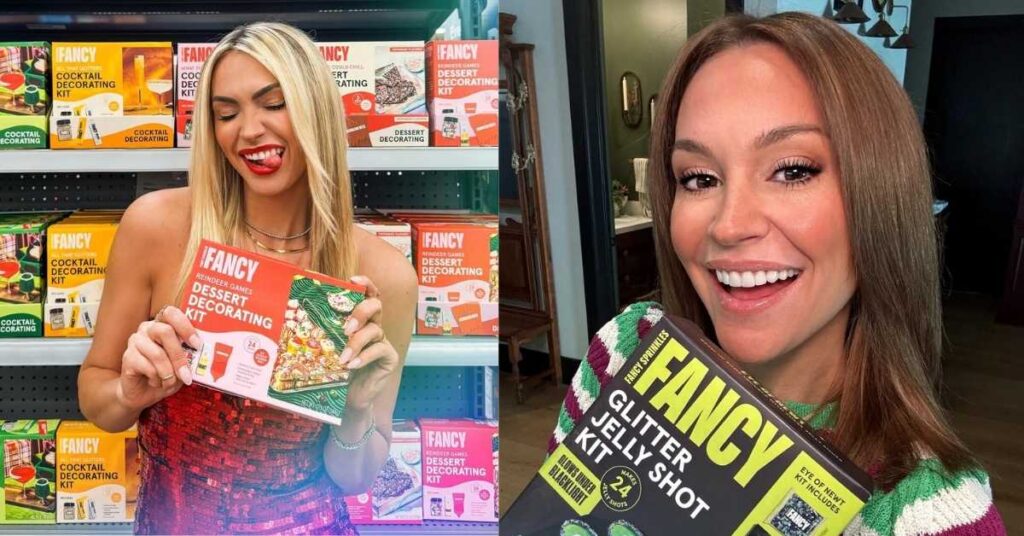 Lisa Stelly smiles while holding a Fancy Glitter Jelly Shot kit that includes ingredients for 24 shots and glows under blacklights.