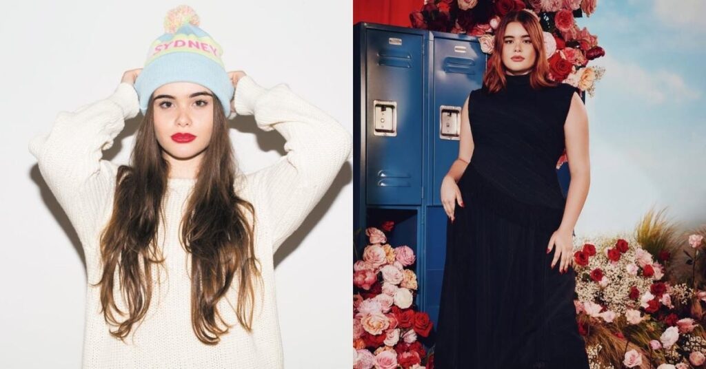 Barbie Ferreira stands in front of blue lockers surrounded by roses, wearing a black sleeveless dress and black boots.