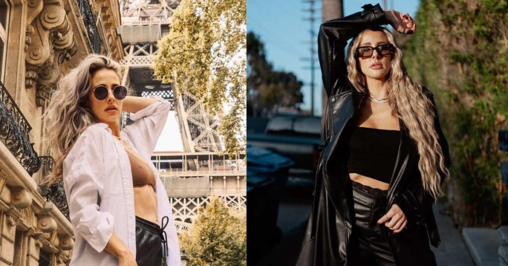 Brittany Schmitt, with long, wavy blonde hair, wearing sunglasses, a black tube top, black leather shorts, and a black leather trench coat, posing with one arm raised.