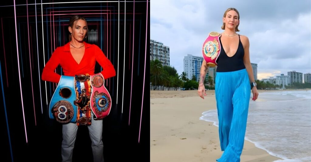 Mikaela Mayer, wearing a championship belt, walks on a beach in blue pants and a black swimsuit.