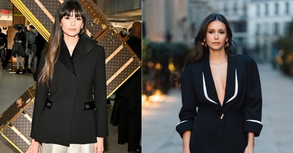 Nina Dobrev, in a black blazer with white trim and a plunging neckline, stands outdoors holding a black handbag.