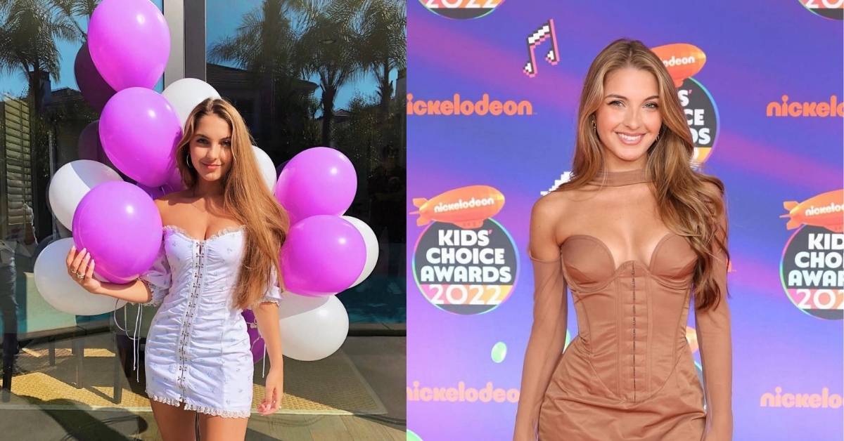 A person in a white dress holding a bunch of purple and white balloons.