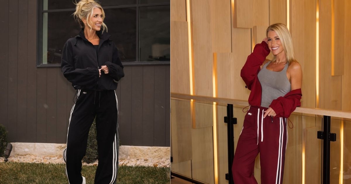 Kalee Rogers, in a black jacket and black pants with white stripes, stands outside on the grass.